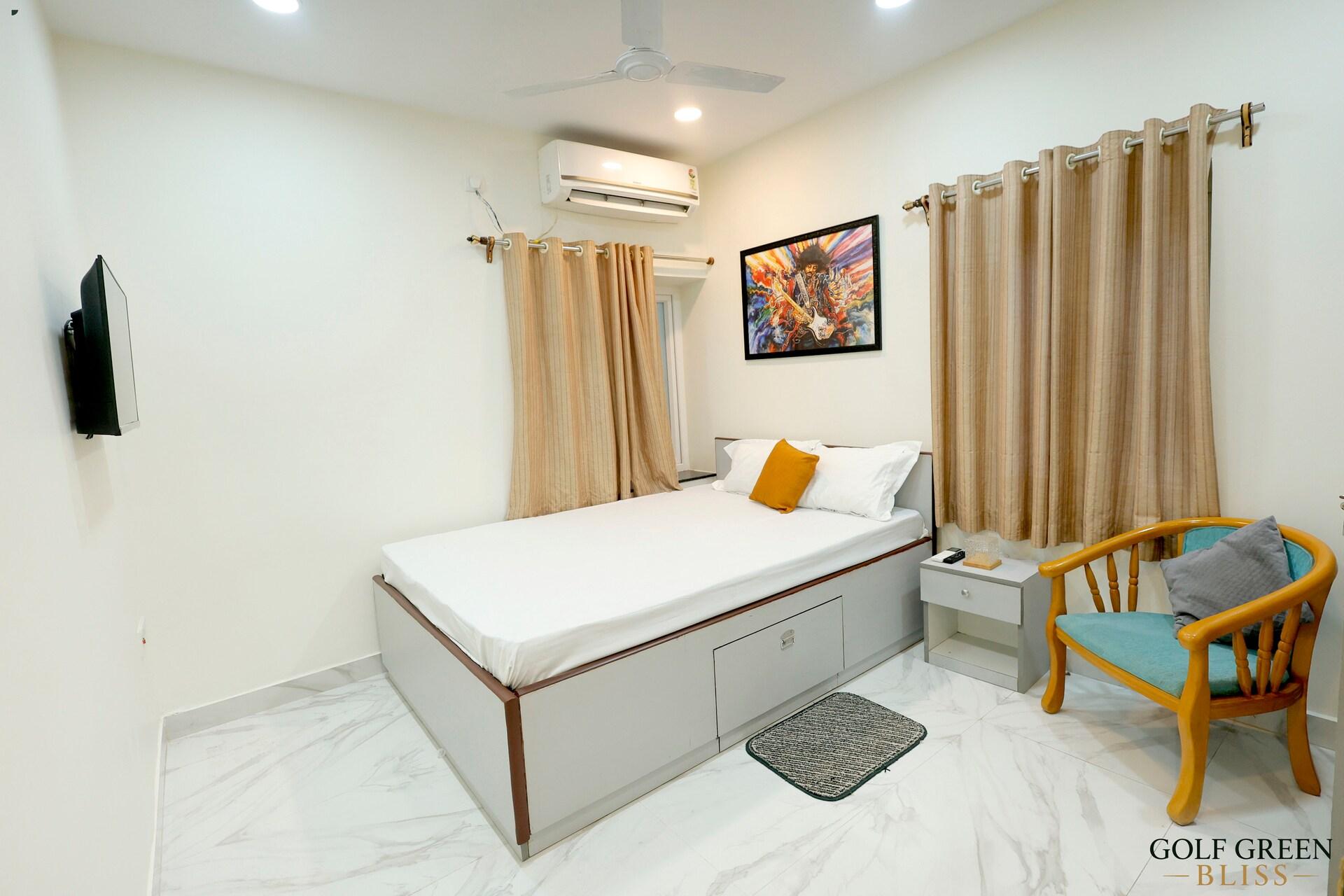 Bedroom one seen from the doorway, with the bed, artwork and armchair