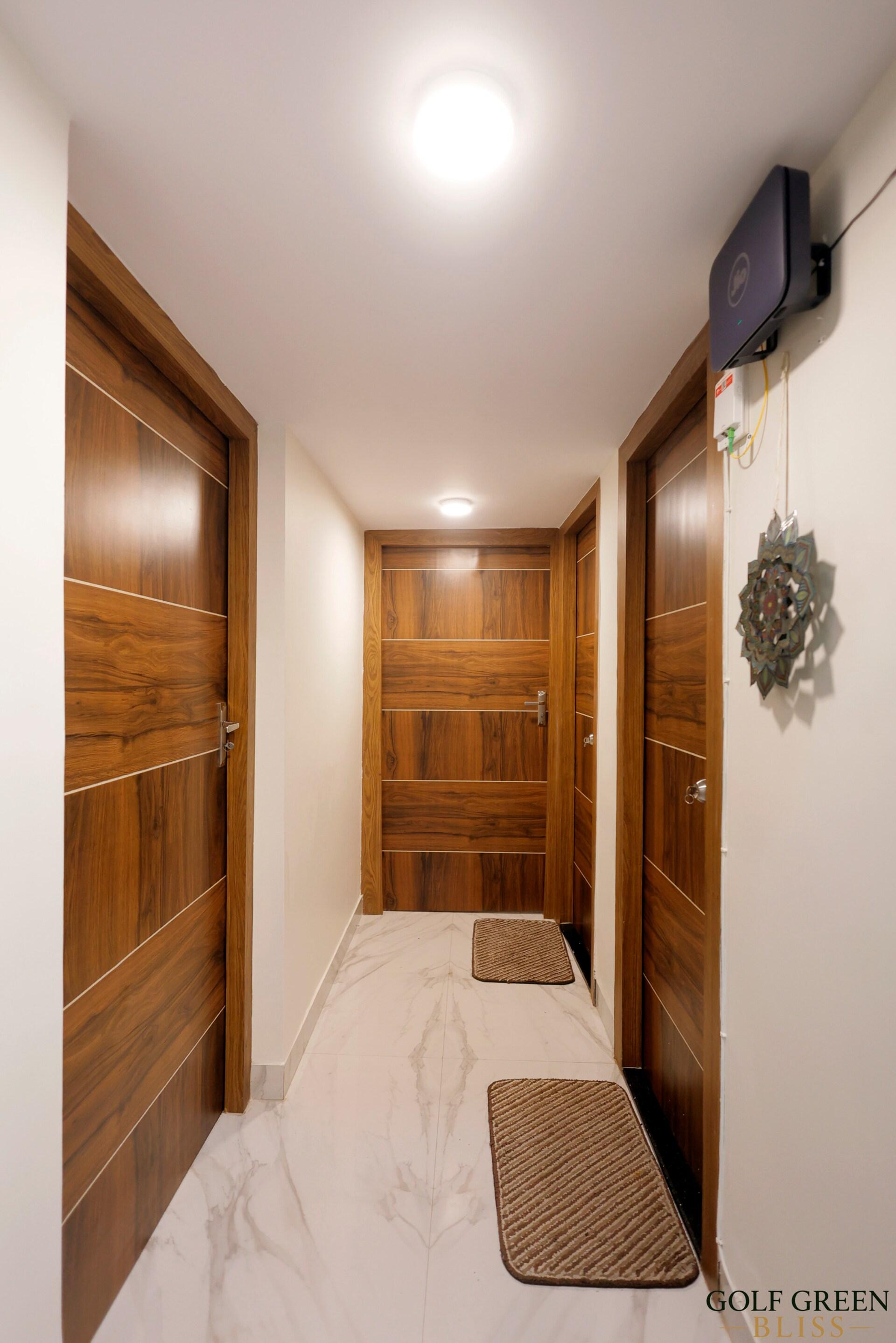The entrance hallway with polished wooden doors and marble flooring