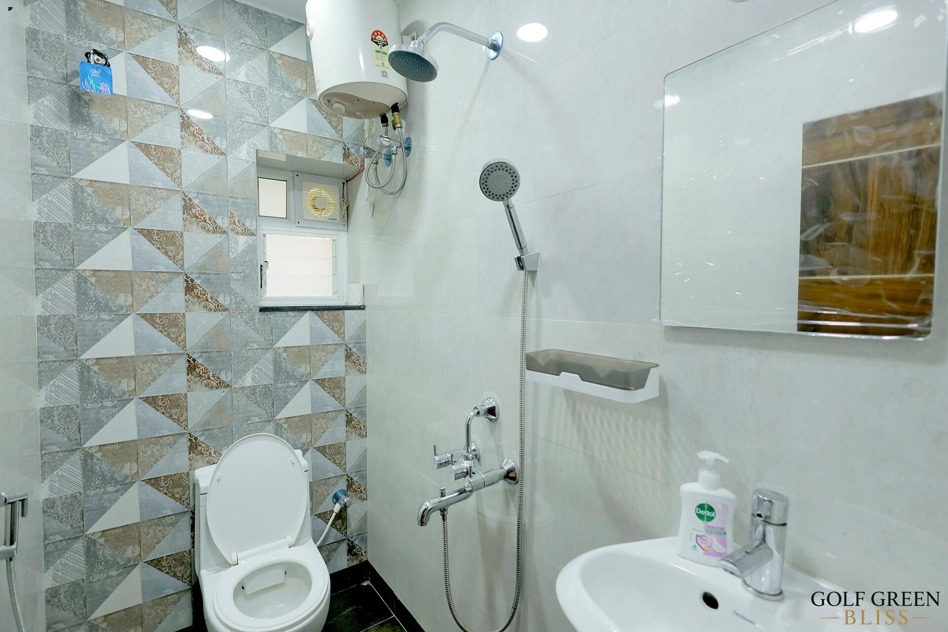 A bathroom with a shower area, WC and washbasin