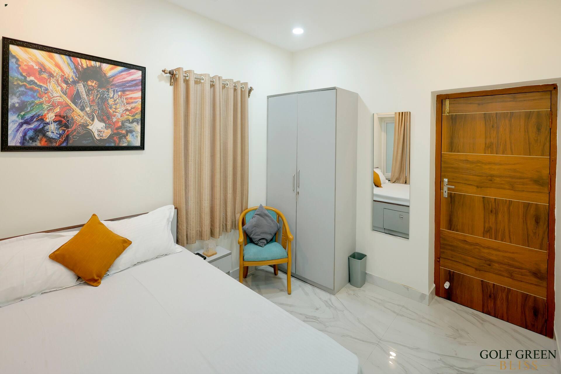 Bedroom one looking towards the wardrobe and the door, with the framed print above the bed